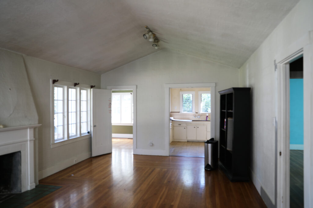 Before renovation interior of older Willow Glen home with outdated kitchen cabinets, old sink, worn walls, ceiling damage, and aging windows.